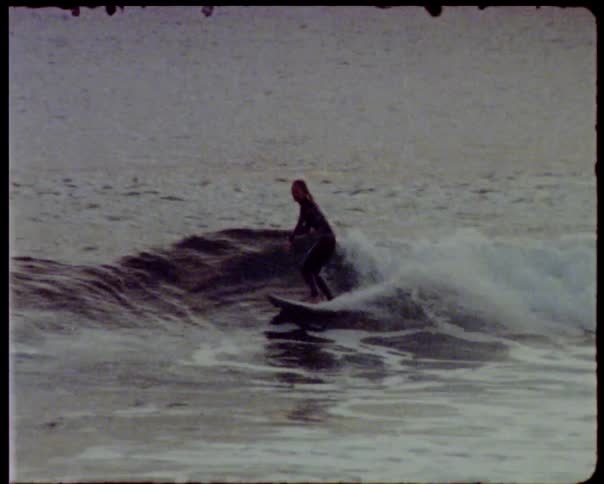 Woman surfs wave on surfboard during the day