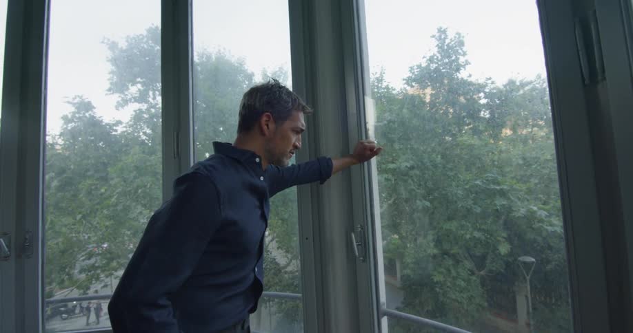 A man is looking out a window