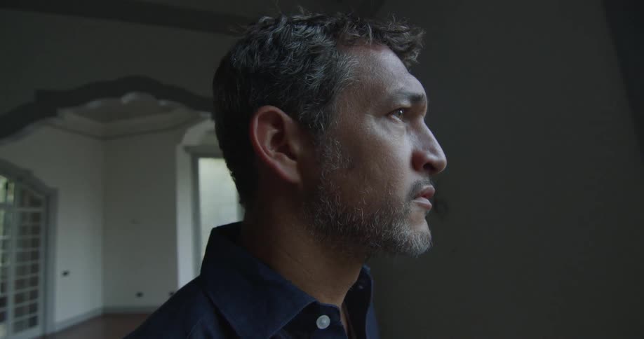 Man gazing off to into the distance inside a home