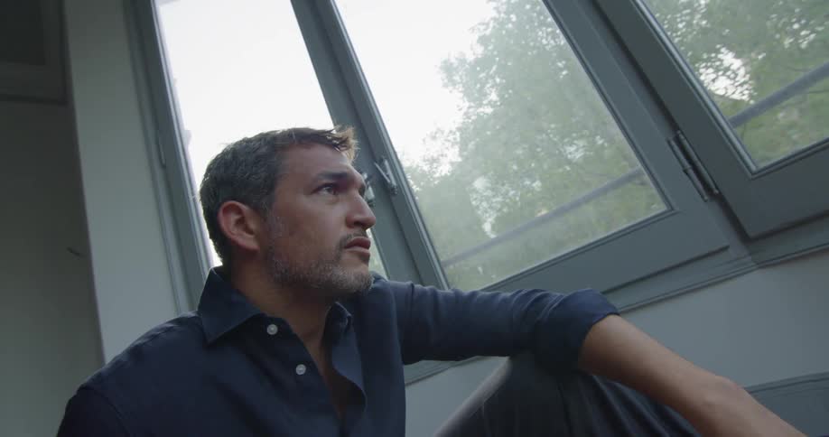 Man sits on floor near window