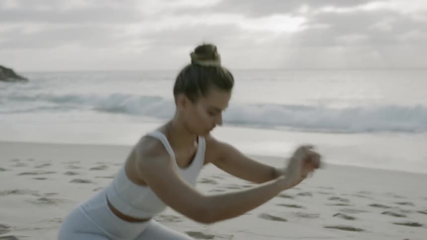A woman exercises on a beach