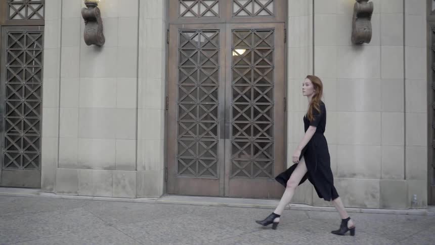A woman walks down the sidewalk