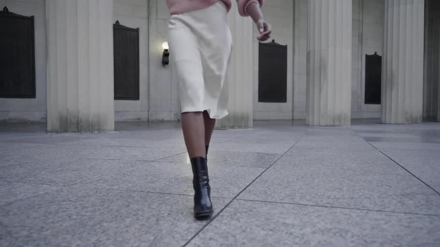 A woman walking across a marble tiled floor