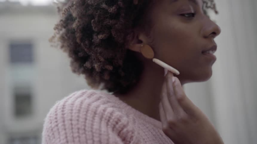 A woman rubbing her neck and earring