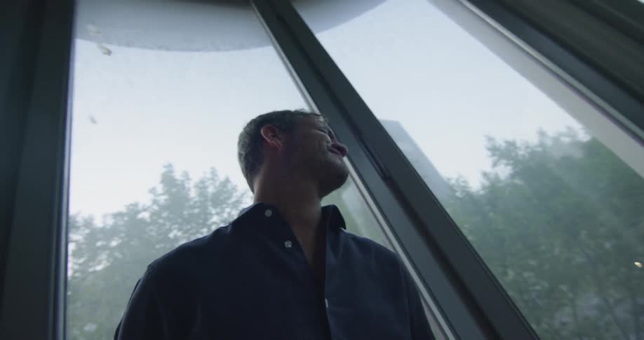 Two people stand near the window