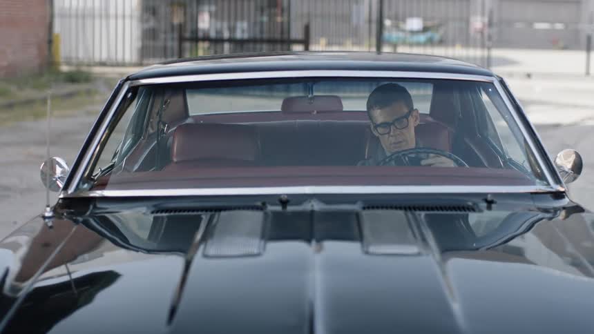 Man in a car looking in his wallet