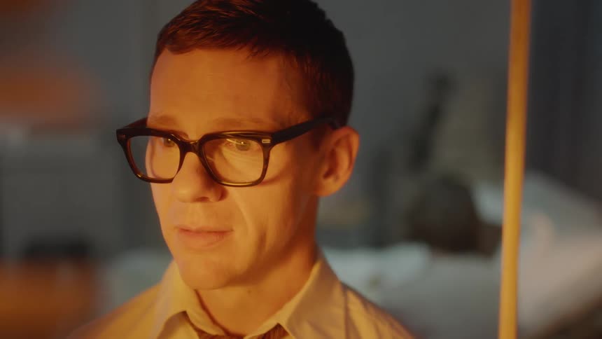 Man wearing glasses looks at blaze in a state of fear