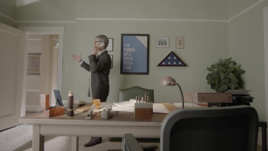 A man is talking on a phone in a building