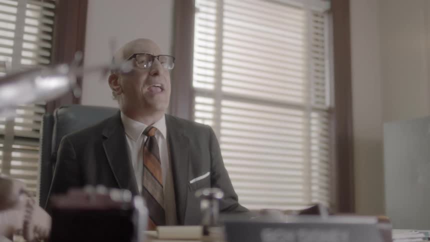 Man pounds desk and shouts in office