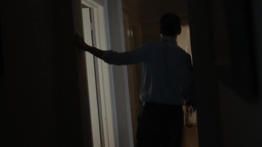 Man walking and stumbling down a hallway
