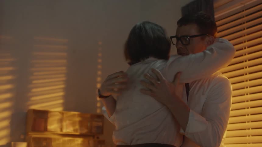 A woman and man are hugging indoors