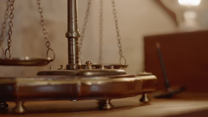 An old fashioned balance scale made of brown wood sits idle