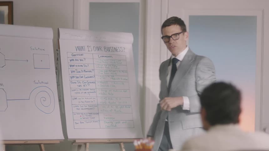 A man discussing what's written on a board