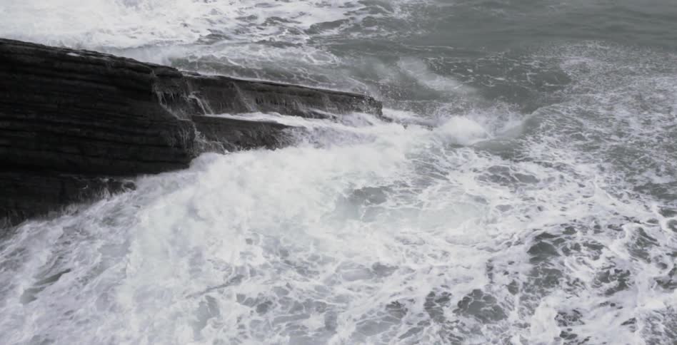 Water rages over some rocks in a body of water