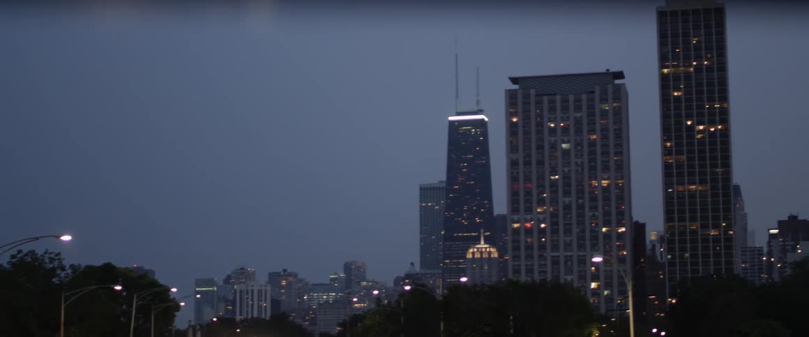 A large city is lit at night on a cloudy day