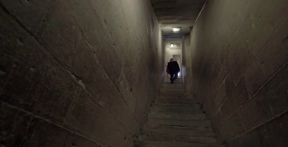 A woman walks up a narrow staircase