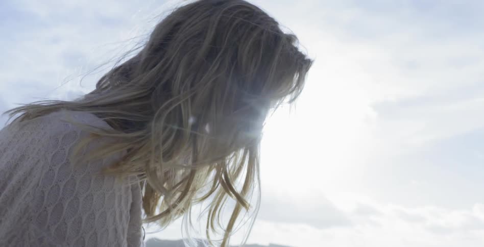 A woman with hair blowing in the breeze