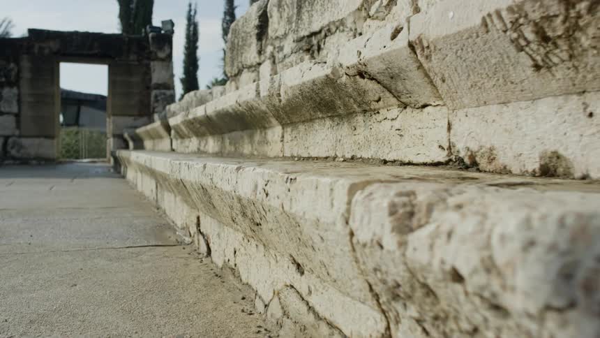 The camera moves along the edge of an old stone step
