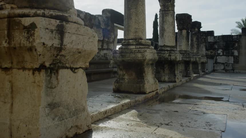 The remains of an ancient building serves as a historical site and is covered in puddles after a recent rain