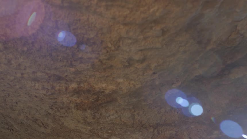 The sun shines down on a large rock
