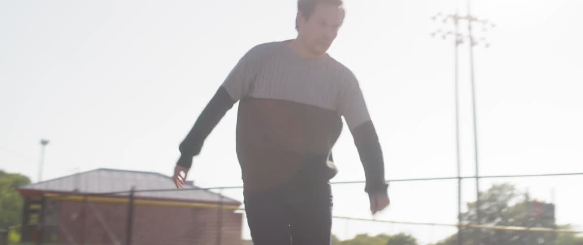 A man skateboarding through an empty parking lot