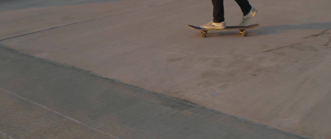 A man skateboarding on a rooftop with the sun in the background