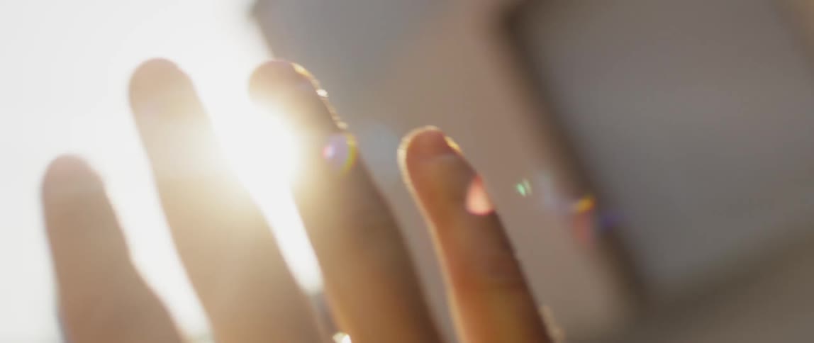 Person holds up their hand to eclipse the sun