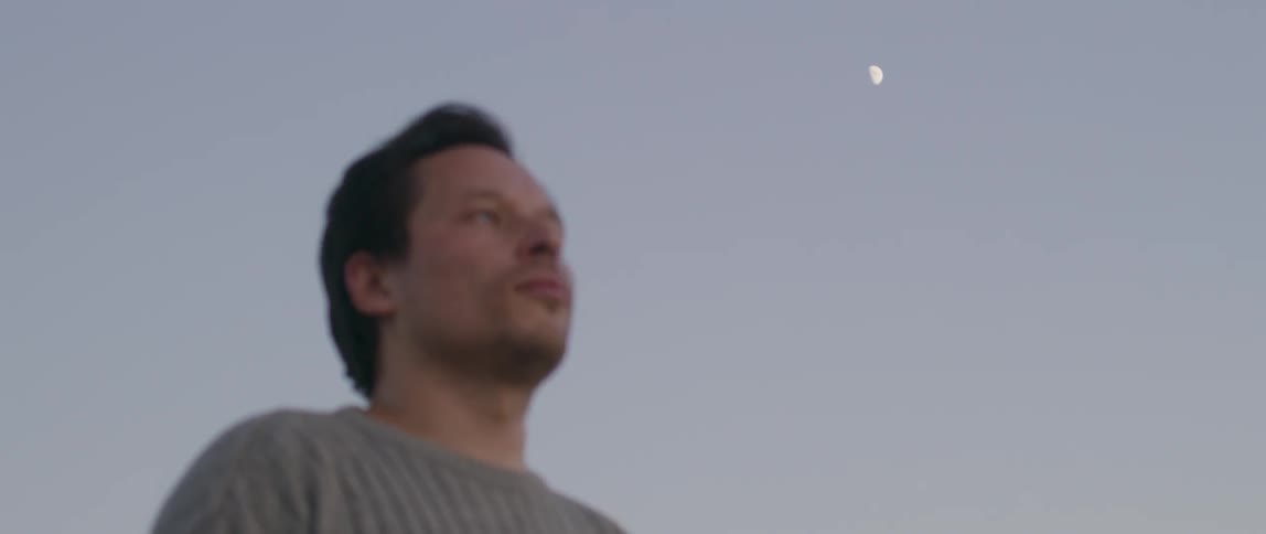 A man looks straight ahead and then turns his head