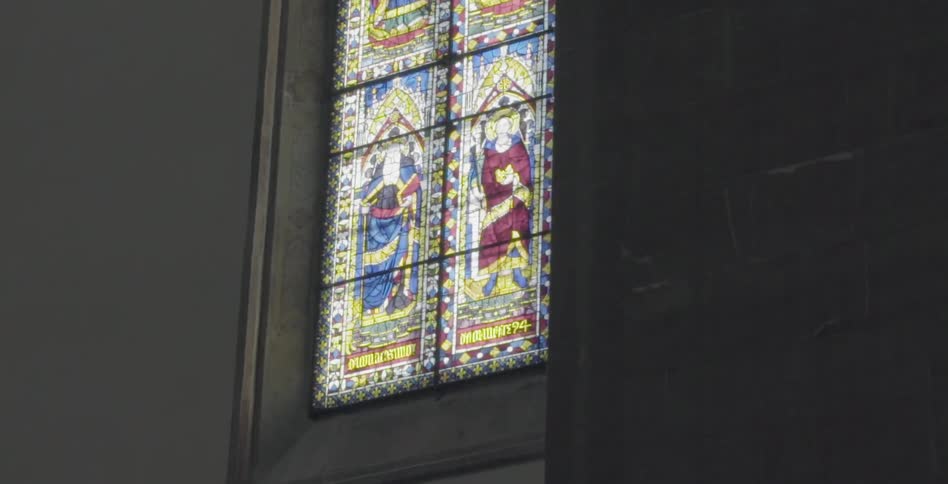 View of a large, stained glass window seen from within a cathedral