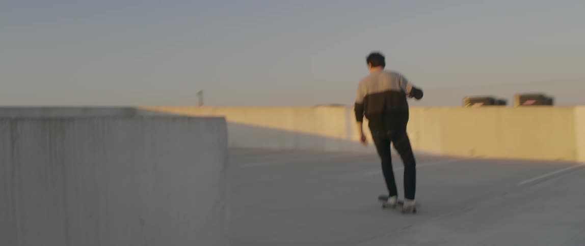Person rides a skateboard around on top of a parking garage