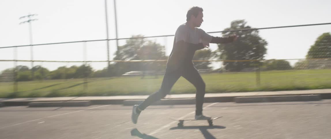 A young man riding a skateboard in a parking lot