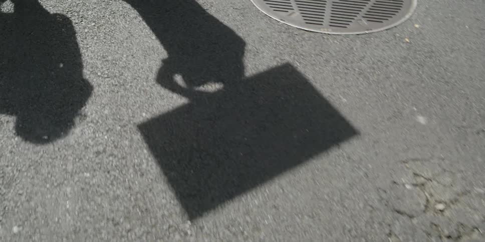 Shadows of people walking and carrying sign