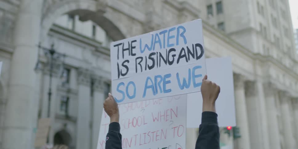 Activists hold signs at a protest in a city