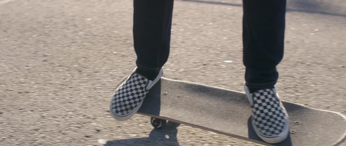 Person moves around on a skateboard in a parking lot