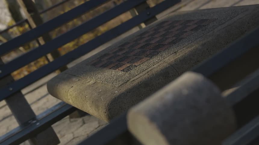 A chess table sits lonely in the park