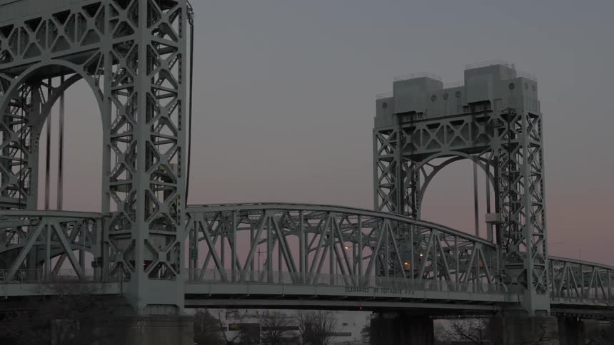 Traveling past a steel bridge at sunset