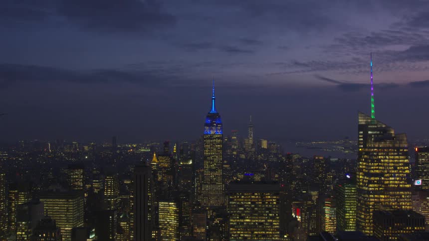 Time lapse of cloudy night sky over brightly lit city