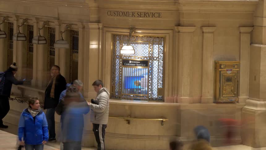 Crowded area with people moving past customer service window