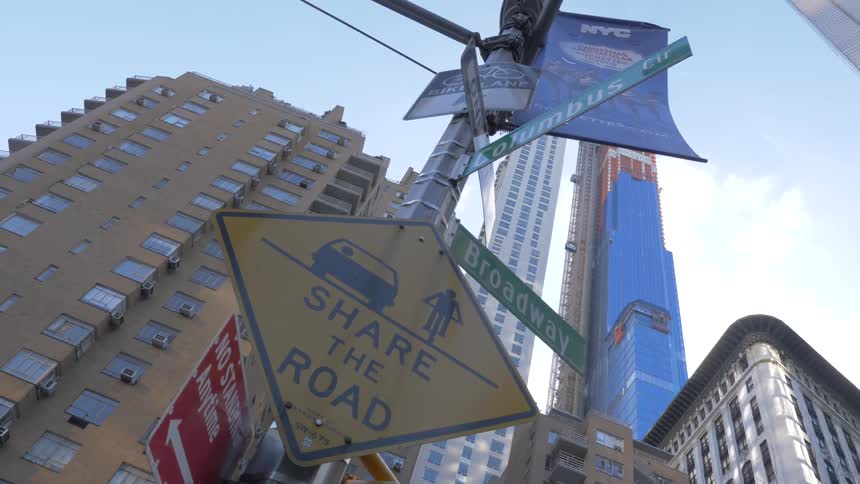 Road signs stand on an urban street corner