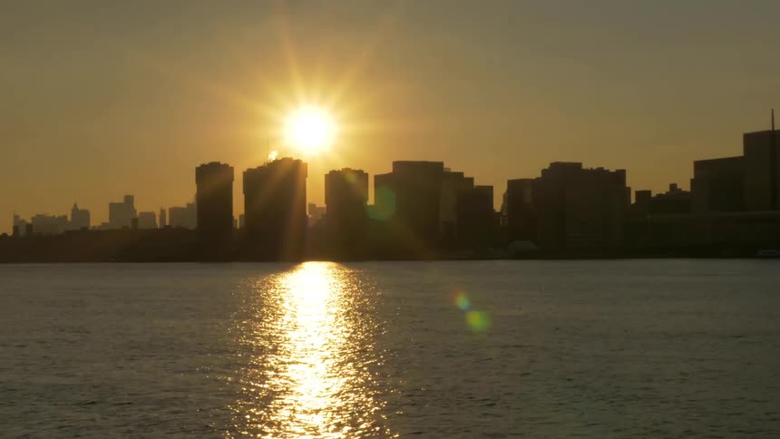 Time lapse of sun setting over city skyline
