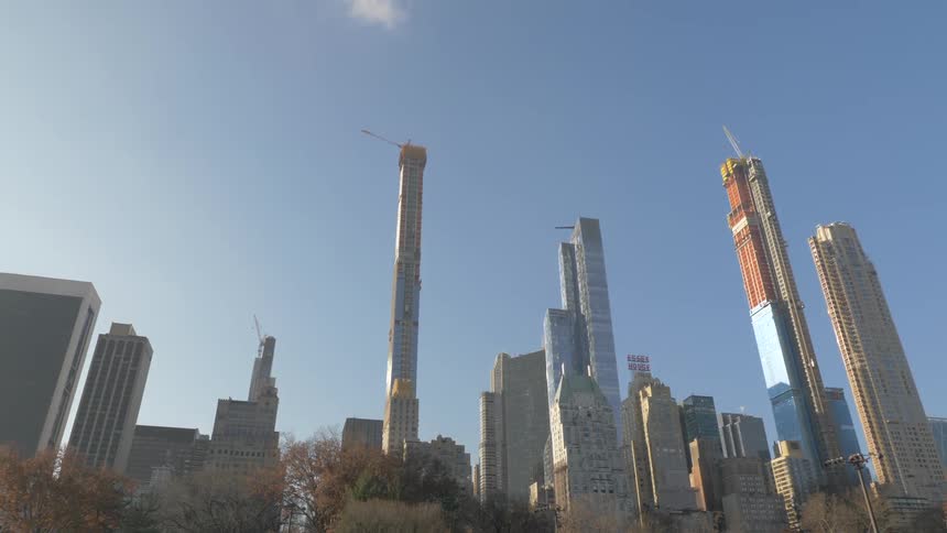 Camera looks up at tall towers in a city
