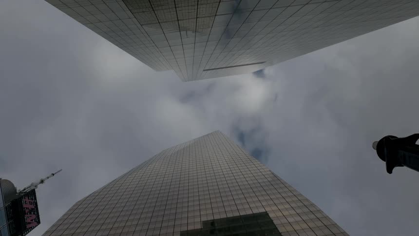 Looking up the side of a skyscraper into a cloudy sky