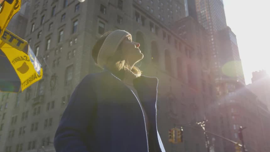 A woman watches the sky downtown