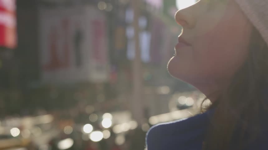 A woman stares to the sky while downtown