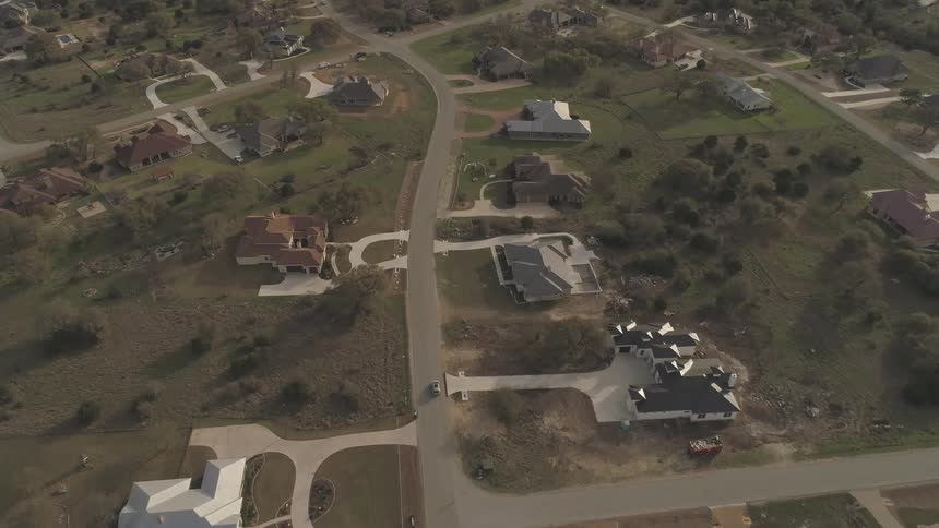 A car travels down a road that leads to many different houses