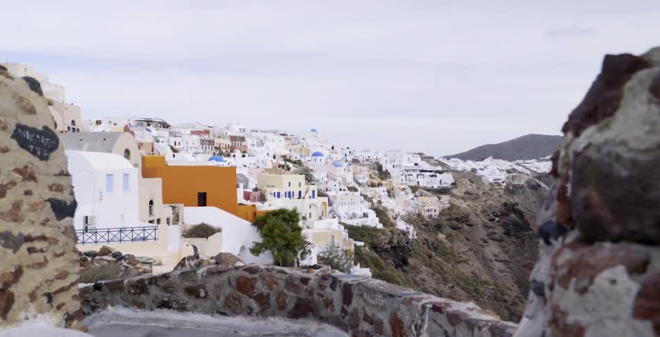 A large town sits on a steep cliff on a cloudy day