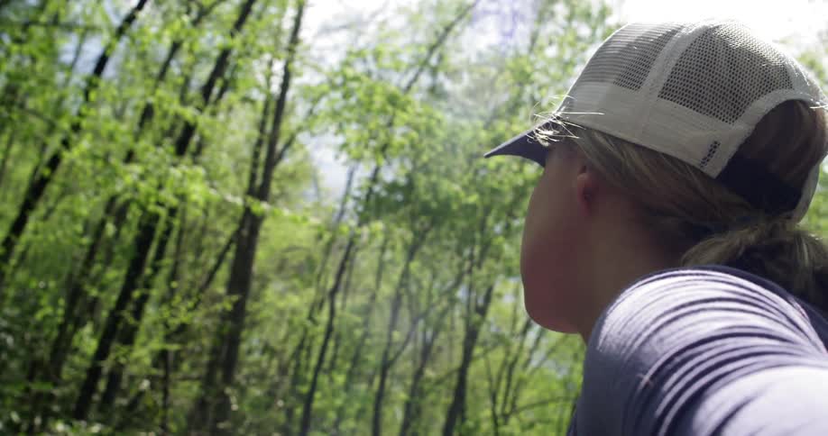 A woman is walking in the woods