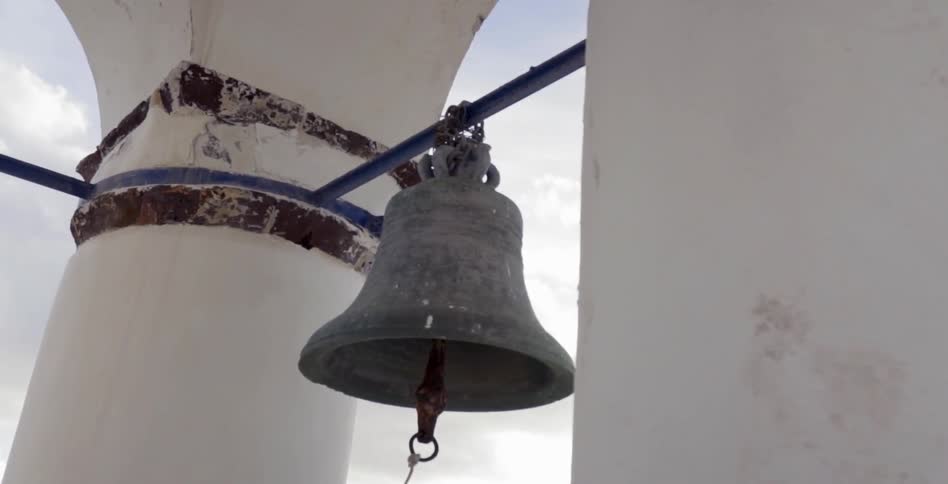 A large bell hanging on a pole
