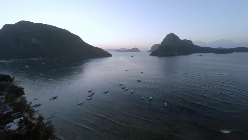 Small boats congregating near a few islands