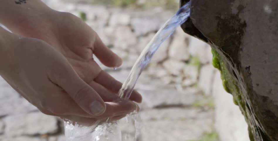 Hands are washed in water pouring from a rock spout